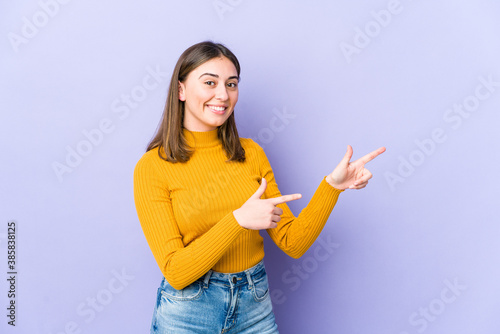 Young caucasian woman excited pointing with forefingers away.