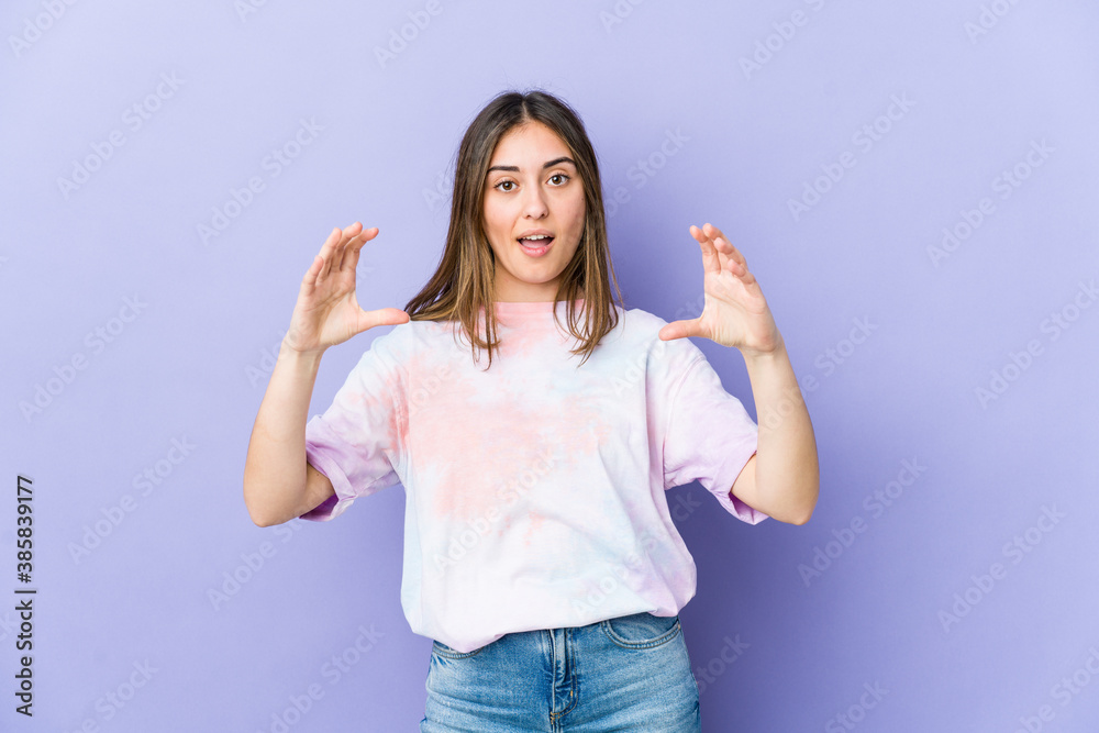 Young caucasian woman holding something with palms, offering to camera. Young caucasian woman holding something with palms, offering to camera.
