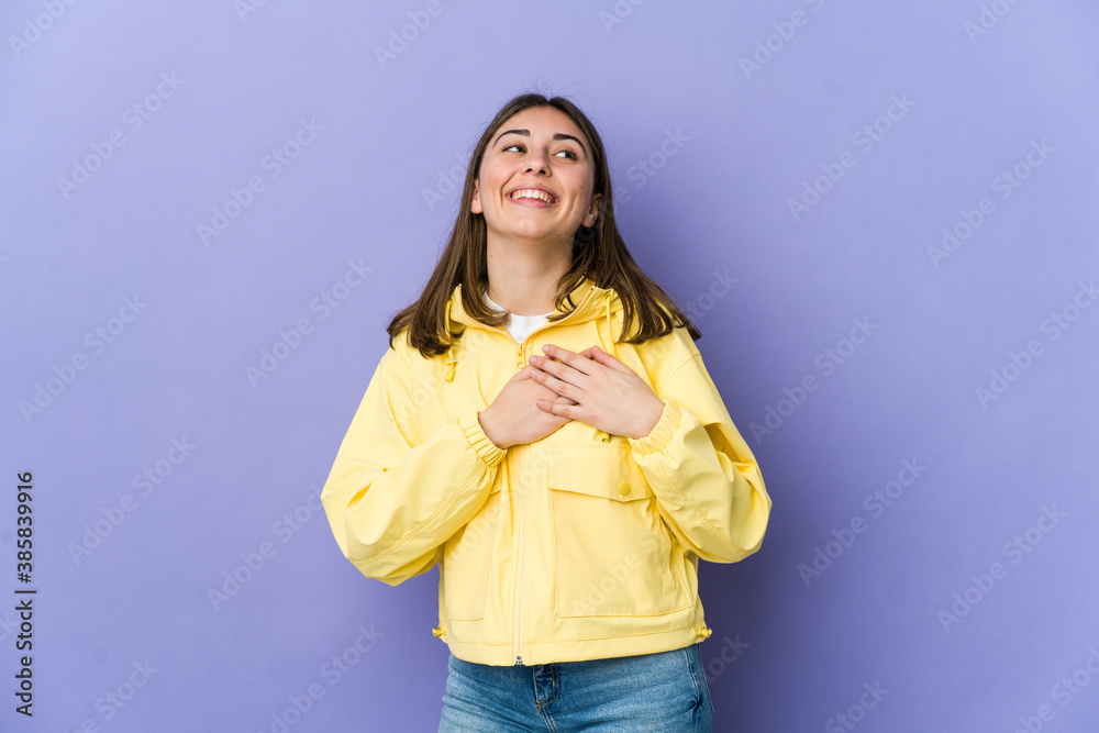 Young caucasian woman laughing keeping hands on heart, concept of happiness. Young caucasian woman laughing keeping hands on heart, concept of happiness.