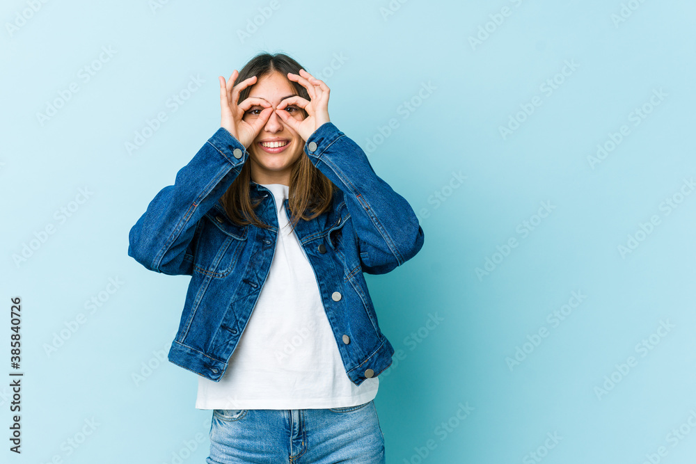 Young caucasian woman showing okay sign over eyes