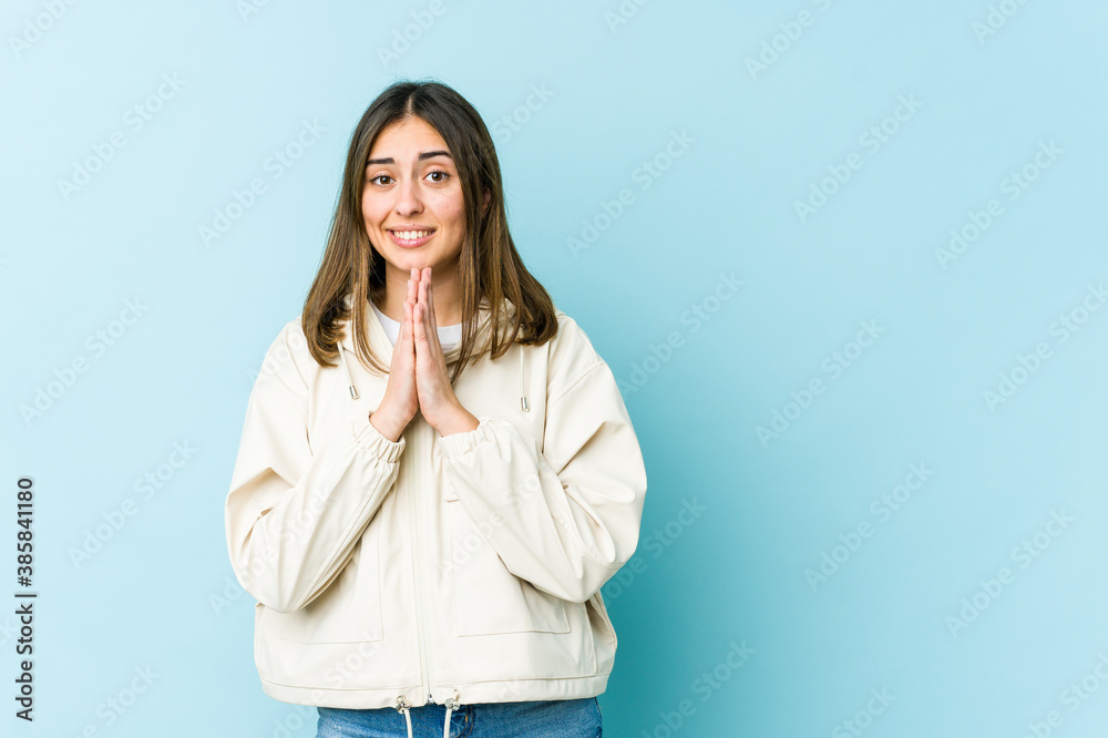 Young caucasian woman holding hands in pray near mouth, feels confident. Young caucasian woman holding hands in pray near mouth, feels confident.