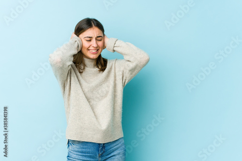 Young caucasian woman covering ears with hands.