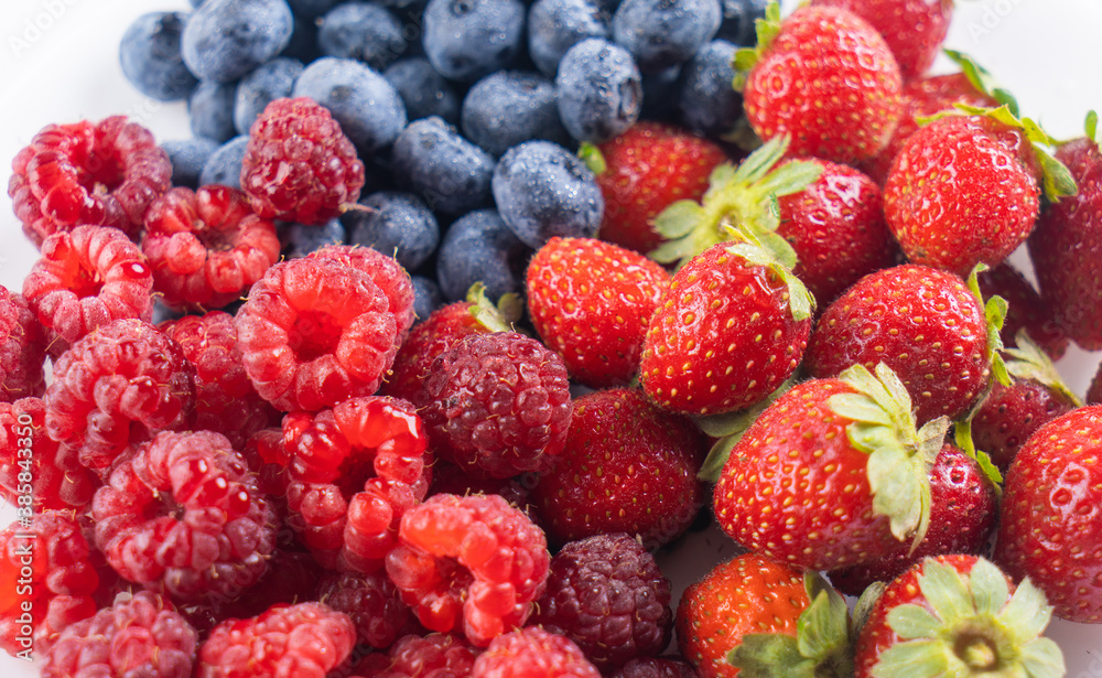 Fresh tasty berries background. Strawberries, blueberries and raspberries close up top view Fresh tasty berries background. Strawberries, blueberries and raspberries close up top view