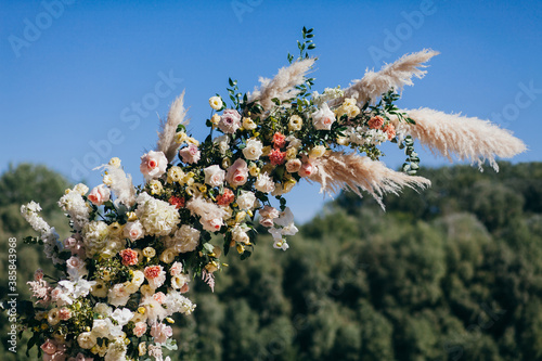 Quadro su tela Wedding round arch in rustic style decorated with a composition of fresh flowers for an outdoor wedding ceremony