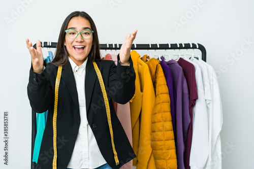 Young asian designer woman isolated on white background receiving a pleasant surprise, excited and raising hands.