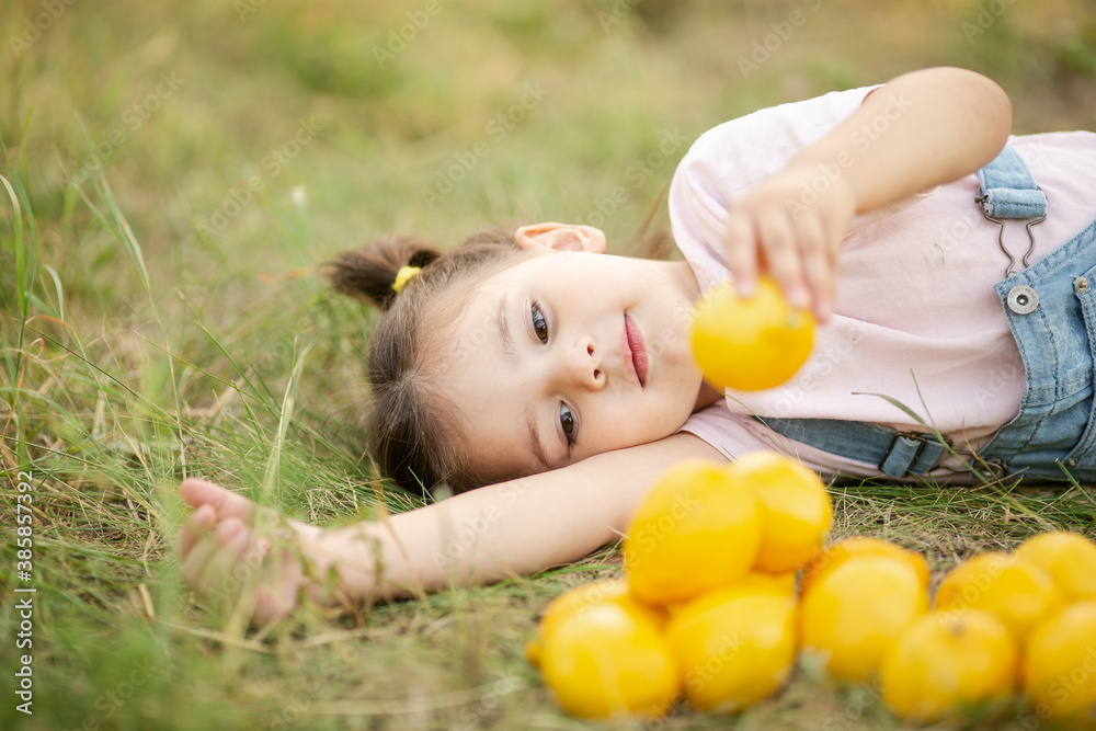 Cute little girl in nature with lemon under lemon tree in summer Cute little girl in nature with lemon under lemon tree in summer
