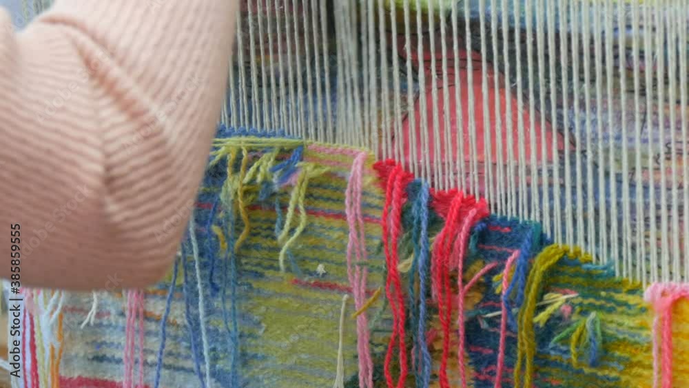 Handmade carpet embroidery. Women's hands create a pattern using multi-colored threads. Hammer for embroidery quors, stuffing threads. Close up view. Handmade carpet embroidery. Women's hands create a pattern using multi-colored threads. Hammer for embroidery quors, stuffing threads. Close up view.