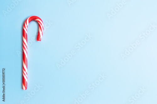 Candy cane on a blue background. Christmas sweets.