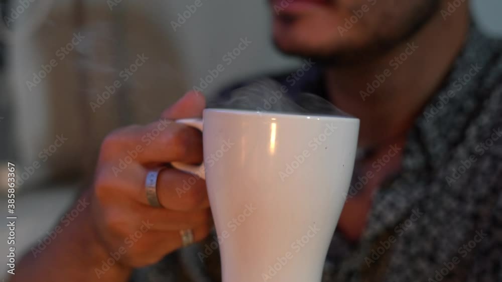 Chico joven bebiendo bebida caliente