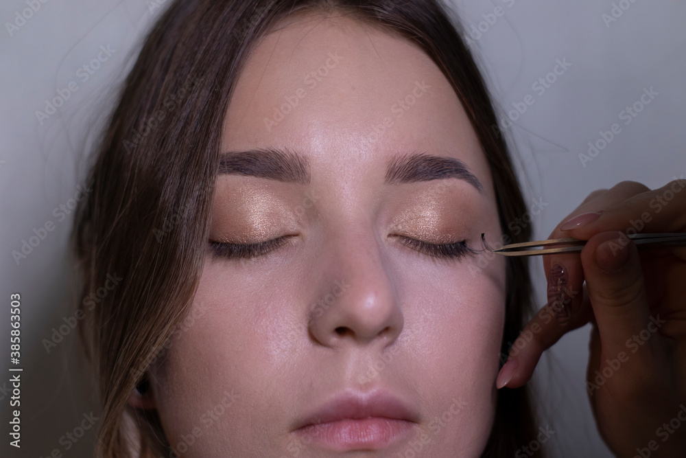Obraz premium the process of applying makeup to a beautiful brunette. beauty, modeling and cosmetics concept. 