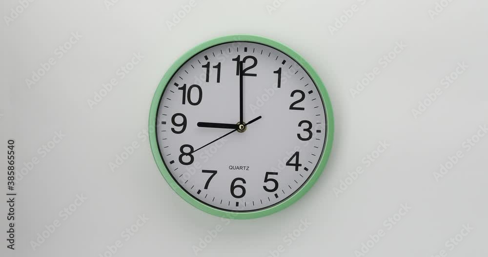 Quartz wall clock on a white background. The clock shows nine o'clock. 4K DCI video. Quartz wall clock on a white background. The clock shows nine o'clock. 4K DCI video.