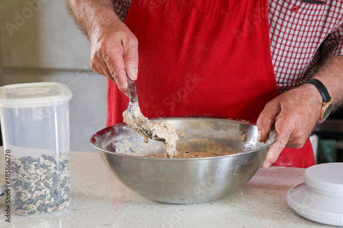 A baker mixing dough for a loaf of spelt bread.