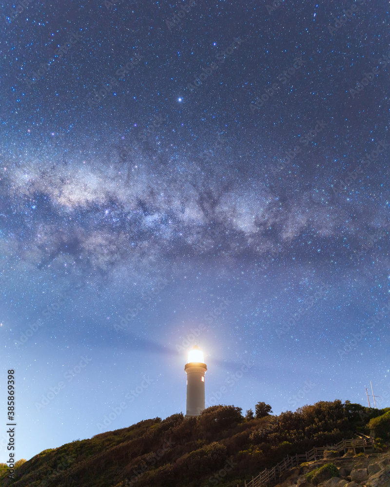 Night view of Norah Head lighthouse with milky way above it.