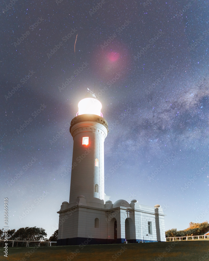 Night view of Norah Head lighthouse with starry sky.