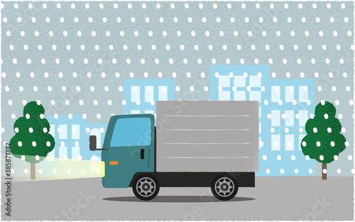 吹雪の中、ライトを点けて都市の道路を進む緑色のトラックのベクターイラスト