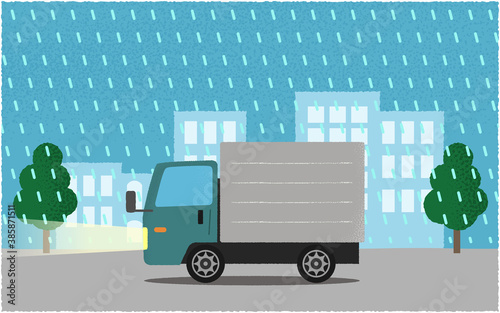 雨の中、ライトを点けて都市の道路を進む緑色のトラックのベクターイラスト