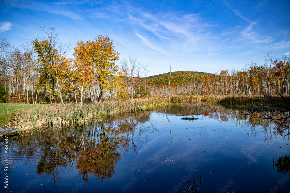 The beauty of autumn colors in the forests reflects off a lake in upstate New York.