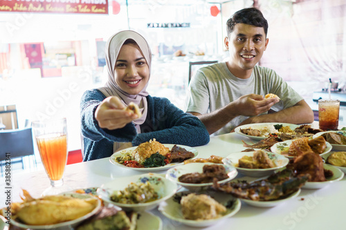 portrait of the couple young eating dish padang food