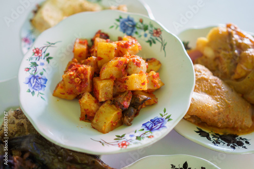 portrait fried potato chilli sauce on a plate on in a traditional food dish