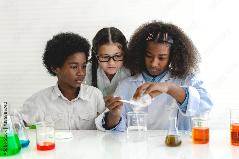 Group of teenage cute little students child learning research and doing a chemical experiment while making analyzing and mixing liquid in test tube at experiment laboratory class at school.Education Group of teenage cute little students child learning research and doing a chemical experiment while making analyzing and mixing liquid in test tube at experiment laboratory class at school.Education