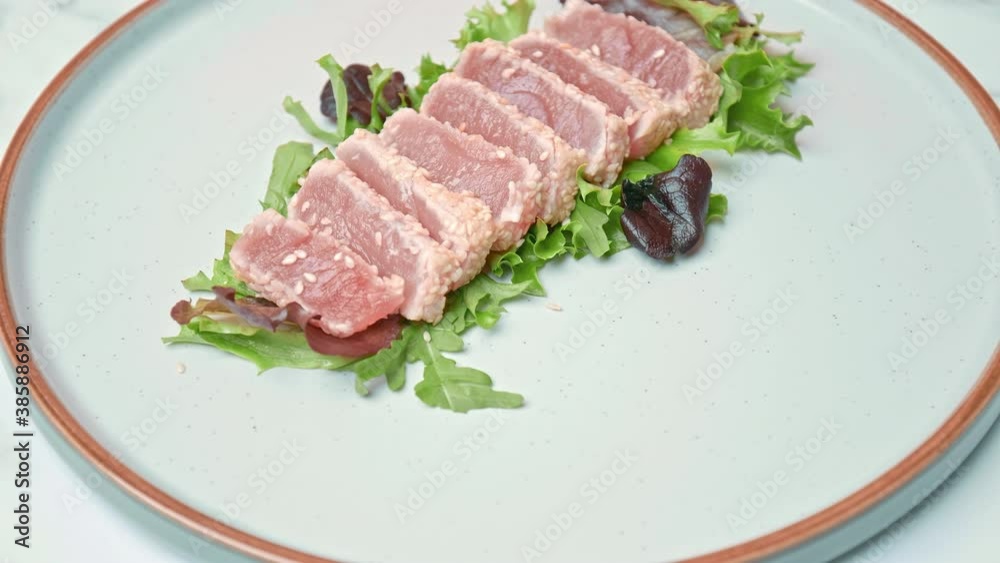 Arranging in a serving plate Seared Tuna with decorative vegetables in 4K. Concept of dressing Tuna and topping up with different spices, coriander, spring onion, red chili, garlic chips. Arranging in a serving plate Seared Tuna with decorative vegetables in 4K. Concept of dressing Tuna and topping up with different spices, coriander, spring onion, red chili, garlic chips.