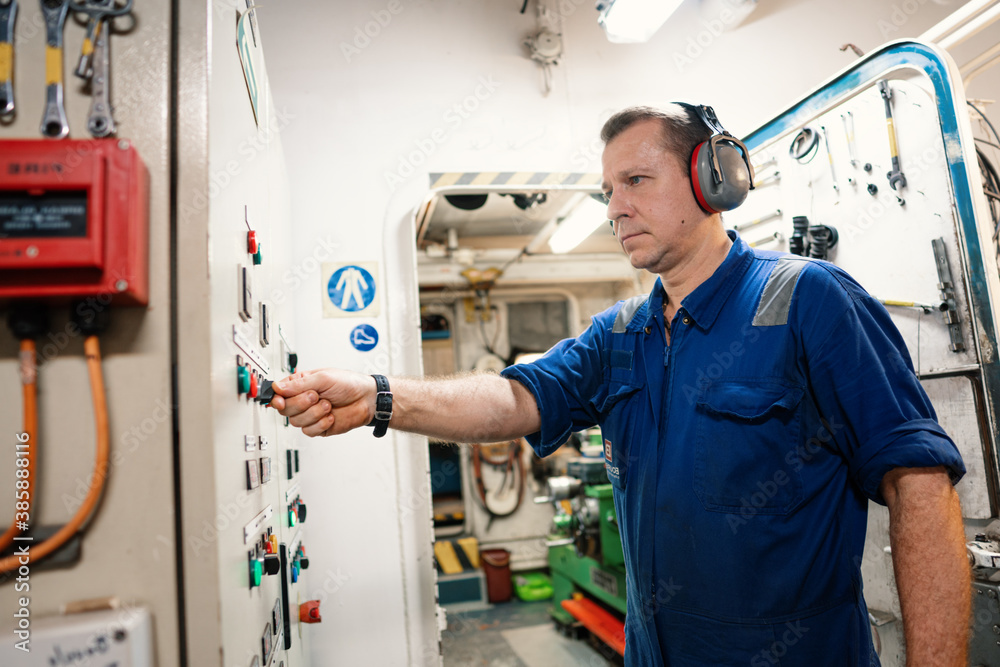 Marine engineer officer controlling vessel enginesand propulsion in engine control room ECR. Ship onboard maintenance Marine engineer officer controlling vessel enginesand propulsion in engine control room ECR. Ship onboard maintenance