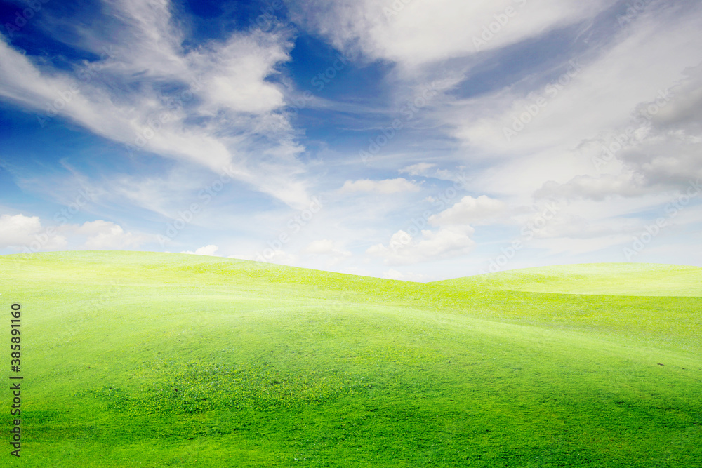 Landscape view of green grass on slope with blue sky and clouds background. Landscape view of green grass on slope with blue sky and clouds background.