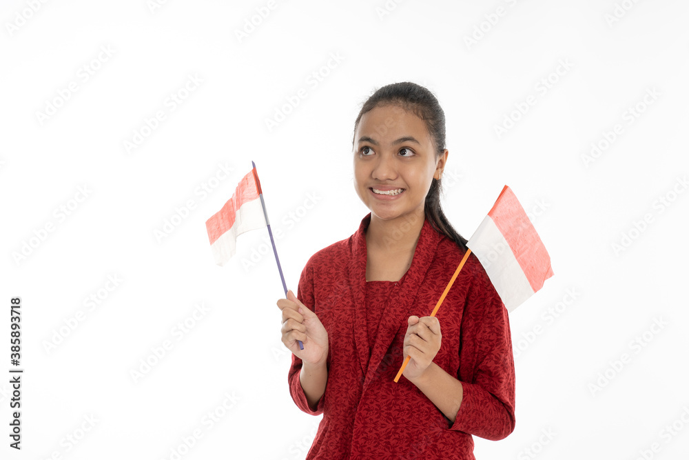 Indonesian girl grab red and white flag. Wearing red kebaya traditional clothes Indonesian girl grab red and white flag. Wearing red kebaya traditional clothes