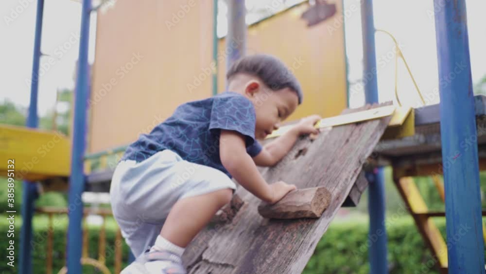 Funny toddler boy playing on colorful playground park enjoying outdoor Funny toddler boy playing on colorful playground park enjoying outdoor