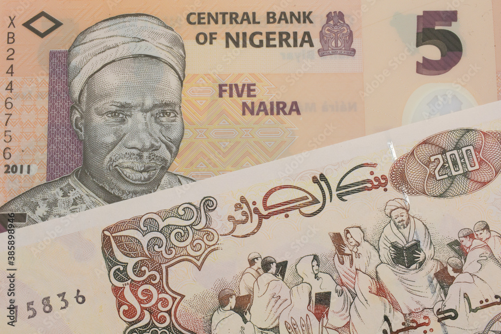 Obraz premium A macro image of a orange, plastic five naira note from Nigeria paired up with a beige 200 Algerian dinar bank note. Shot close up in macro.