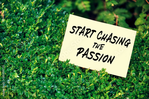 Motivational quote start chasing the passion written on paper in a garden with green plants in nature. © Cagkan