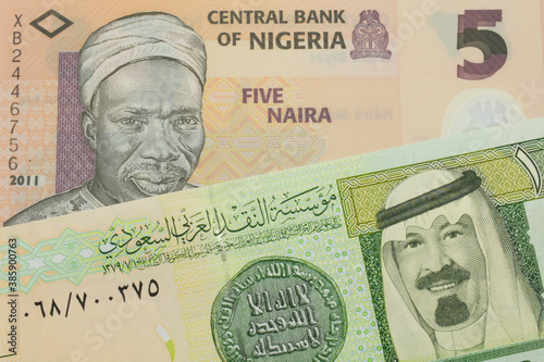 Wallpaper Mural A macro image of a orange, plastic five naira note from Nigeria paired up with a green and yellow on riyal bank note from Saudi Arabia.  Shot close up in macro. Torontodigital.ca