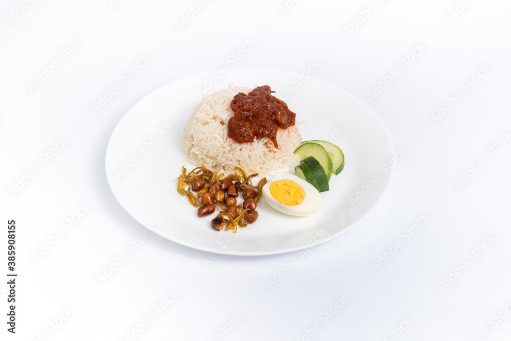 Nasi Lemak-Malaysian cuisine. A fragrant rice dish cooked in coconut milk and pandan leaf commonly found in Malaysia. Served with sambal, anchovies, peanut, and cucumber. center of the frame