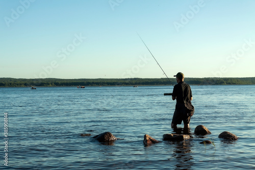 A fisherman catches fish in the evening sunset