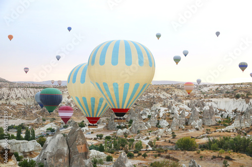 Beautiful colourful balloons flight in the morning in Cappadocia in Turkey. Amazing landscape background.