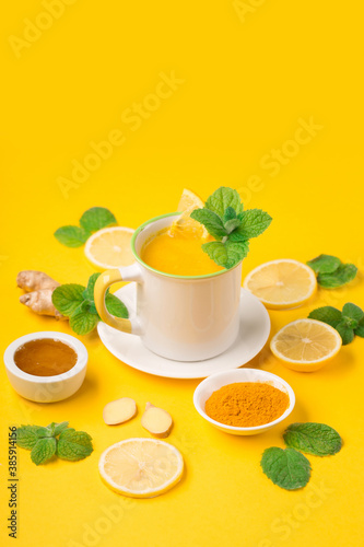 Lemon and ginger tea with honey on paper background.