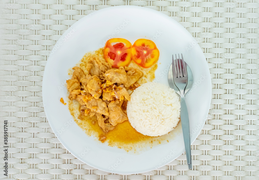Fried pork with garlic on white plate. White pattern background. Copy space.