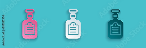 Paper cut Sauce bottle icon isolated on blue background. Ketchup, mustard and mayonnaise bottles with sauce for fast food. Paper art style. Vector.