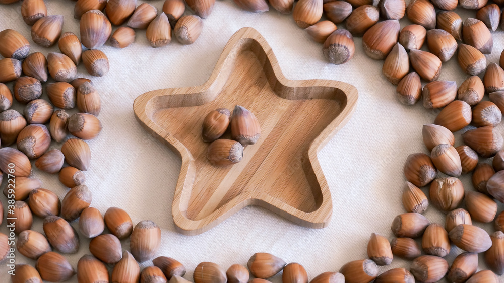 Raw hazelnuts on bamboo star shape plate. High quality photo Raw hazelnuts on bamboo star shape plate. High quality photo