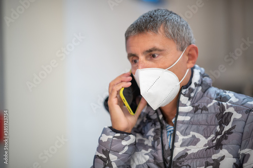 Caucasian man wearing a mask during a phone call. Lifestyle in the pandemic coronavirus covid19