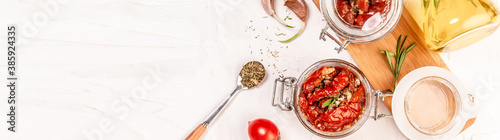 sandwich with goat cheese, sun-dried tomatoes and garlic, oregano, olive oil on a light table. space for text. top view. Long banner format photo