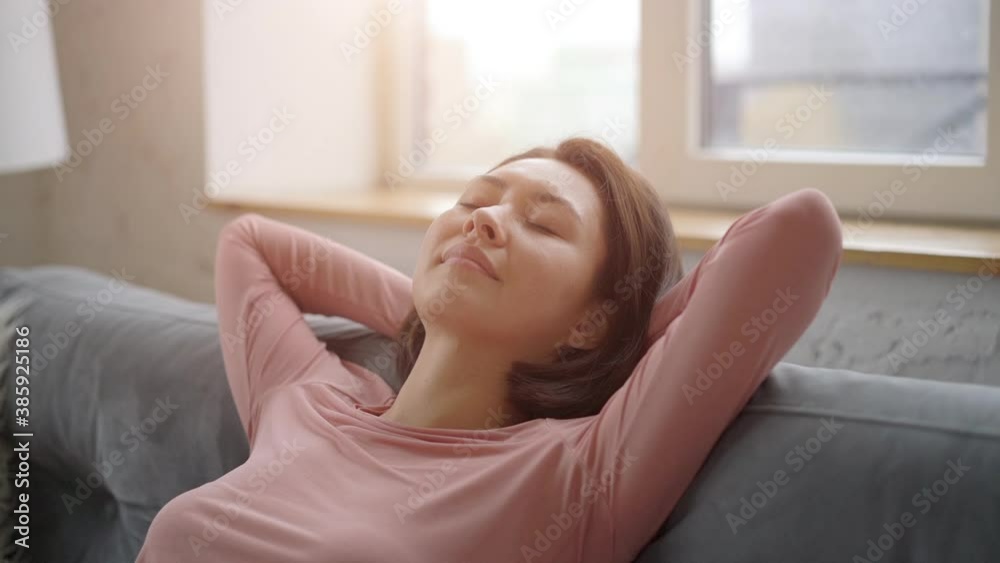 Attractive young asian woman resting on cozy sofa taking deep breath of fresh air holding hands behind head, happy calm ethnical lady relaxing and dreaming on comfortable couch feel stress free Attractive young asian woman resting on cozy sofa taking deep breath of fresh air holding hands behind head, happy calm ethnical lady relaxing and dreaming on comfortable couch feel stress free
