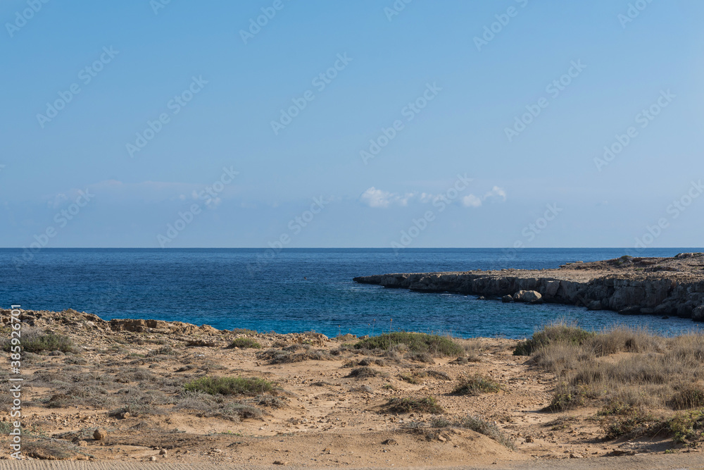 Rocky beach of Mediterranean Sea near the Cavo Greco cape on Cyprus, Agia Napa. Bright sunny day with cloudless sky