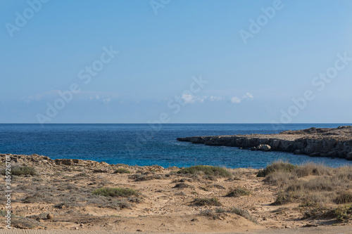 Rocky beach of Mediterranean Sea near the Cavo Greco cape on Cyprus  Agia Napa. Bright sunny day with cloudless sky