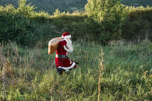 santa claus running in the middle of a field photo