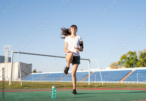 Photos Teenager girl working out at the stadium doing high knees