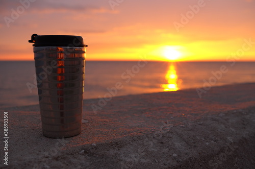 Wallpaper Mural Close shot of a tumbler against background of Sunset over Yellow Sea. Golden sky with clouds. Torontodigital.ca