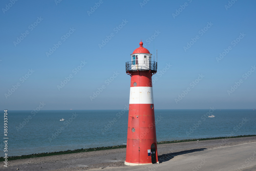 Red and white lighthouse on a blue sky background, Westkapelle in The Netherlands