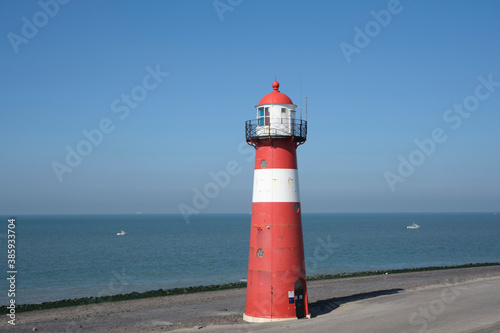 Red and white lighthouse on a blue sky background, Westkapelle in The Netherlands