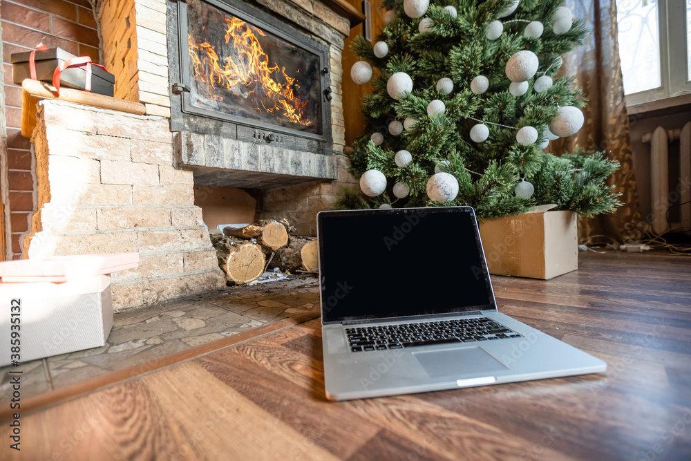 Fototapeta premium laptop and christmas tree in an old wooden house